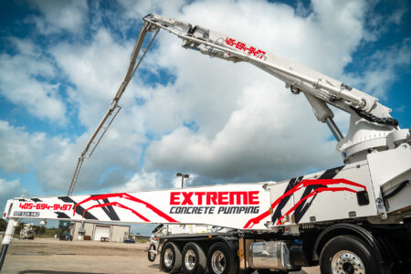 A new DY 52X-5RZ truck-mounted concrete boom pump for Extreme Concrete Pumping, photographed in the front yard of DY Concrete Pumps’ Texas headquarters.
