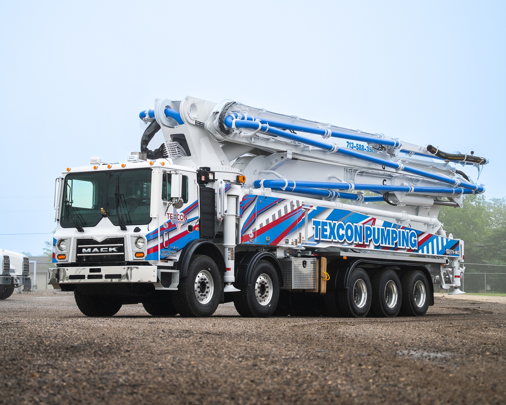 A new DY 57X-6RZ truck-mounted concrete boom pump for Texcon Pumping (Texan Pumpers), photographed in the back yard of DY Concrete Pumps’ Texas headquarters.