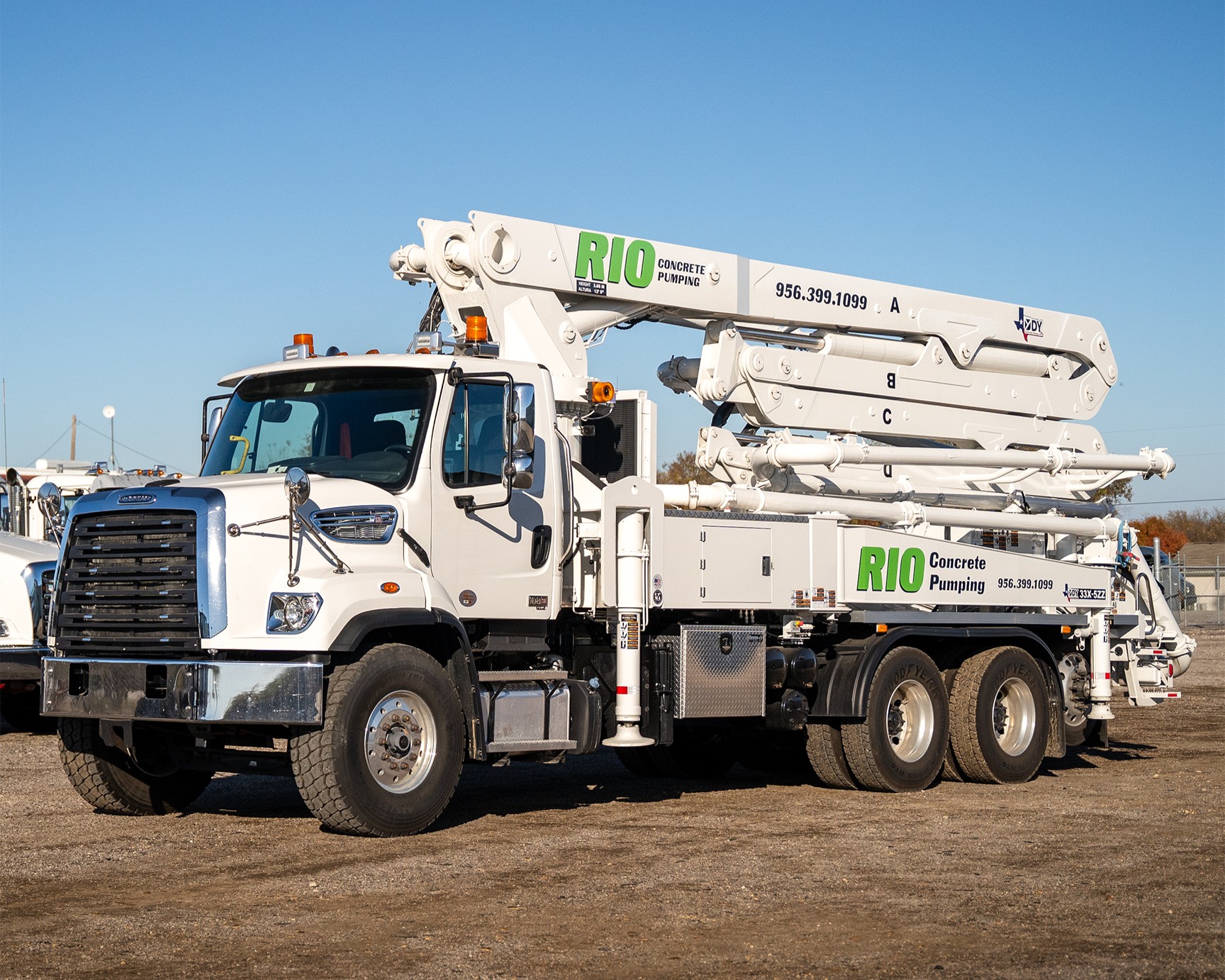 A new DY 33X-5ZZ truck-mounted concrete boom pump for Rio Concrete Pumping, photographed in the front yard of DY Concrete Pumps’ Texas headquarters.