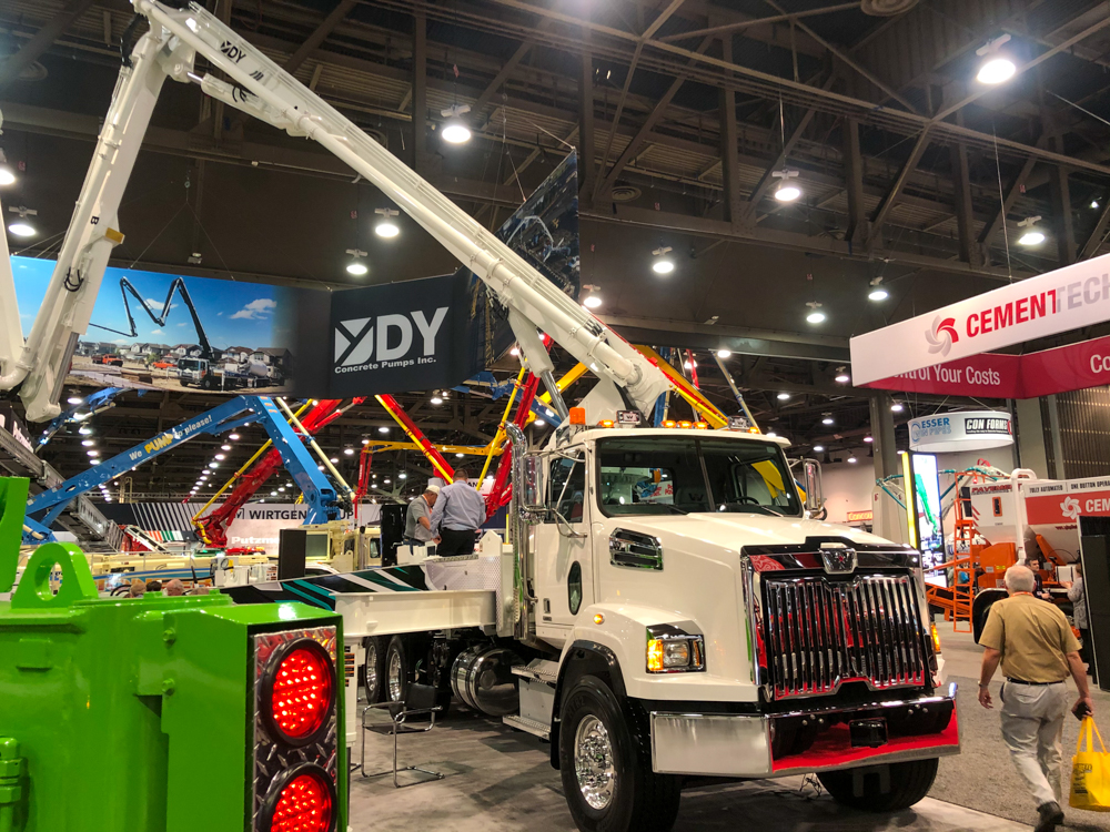 a white DY concrete pump on display inside the WOC event