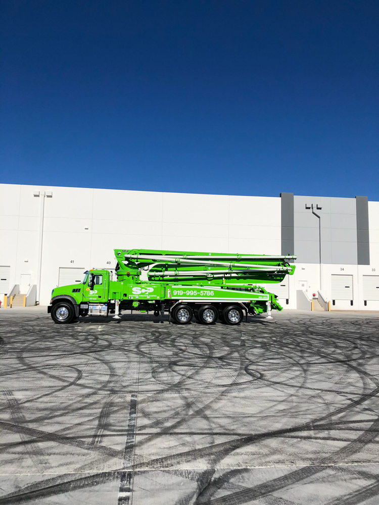 bright green DY concrete pump displayed outside of the WOC event