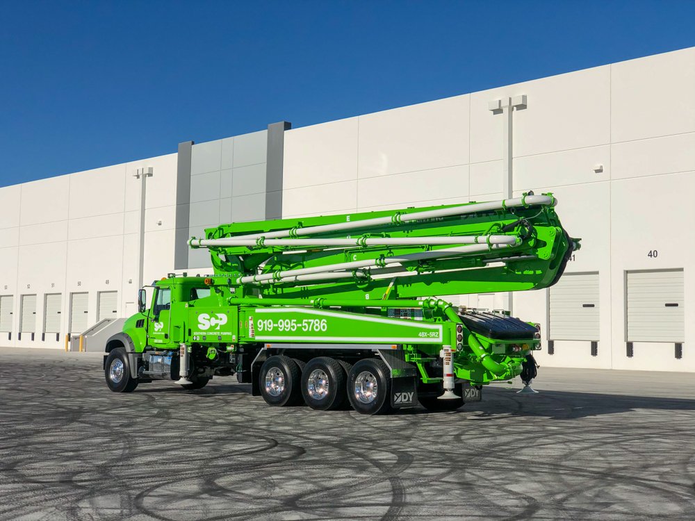lime green DY concrete pump displayed outside of the WOC event